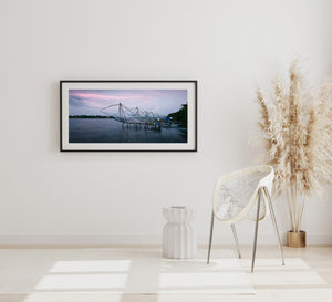Colour photograph of traditional fishing nets beneath a pastel sky