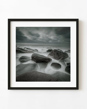 Long exposure of silky waves around dark rocks at Kostbergan Beach.