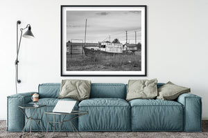 Weathered Lake Nipigon fishing boat resting ashore in an overgrown field.
