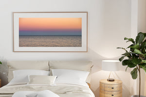 Pastel peach and lavender sky above a calm Lake Ontario horizon