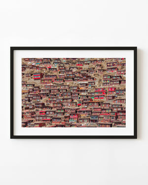 Red wooden homes cover the hillside at Larung Gar Buddhist settlement in China.