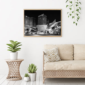Monochrome night photograph of Crystals with palm trees and illuminated storefronts.