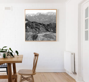 Black and white mountain photograph with folded rock textures and contrasting ridgelines.