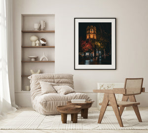 Colour night photograph of LeTAO Tower framed by red and golden autumn foliage.