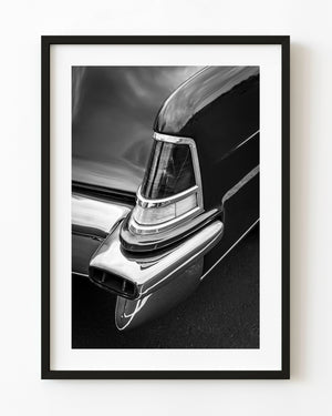 Lincoln Continental tail light and polished chrome bumper in black and white.
