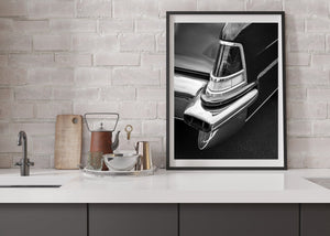 Framed black and white photograph of a classic car's hood ornament on a kitchen counter.