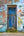 Blue wooden doorway in a peeling painted brick wall with colourful London graffiti