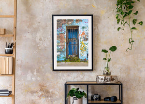 Colourful graffiti beside a weathered blue door and iron gate in London
