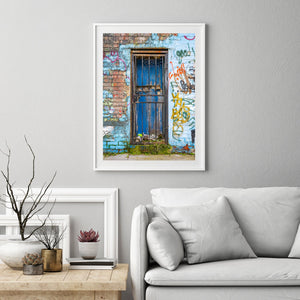 Blue London doorway framed by worn masonry and layered street graffiti