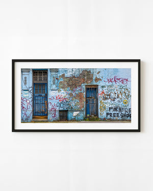 London graffiti wall with blue doors and rusted gates