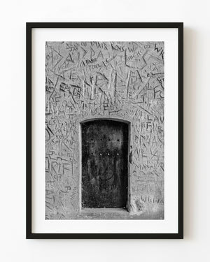 Black and white medieval wooden door set in carved plaster wall England