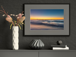 Long Reef Beach morning surf beneath distant clouds and warm horizon light
