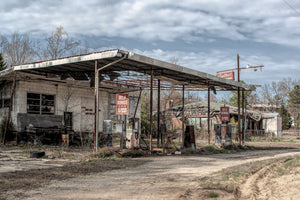 Old gas pumps from different eras at abandoned station