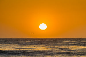 ロサンゼルス近郊の穏やかな太平洋の波に沈む夕日