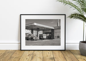 Old Ludlow service station with brick pillars, parked trucks and a no parking sign