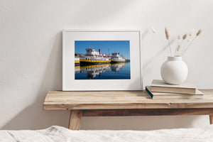 Rippling reflections of white and yellow ferries on deep blue harbour water