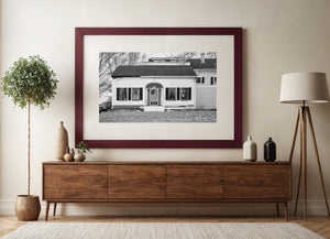 Dark shutters contrast with white siding on a Maine house beneath leafless trees