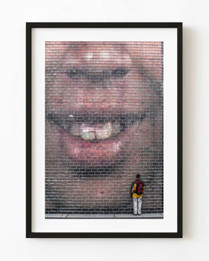 Man with a red backpack facing a giant illuminated face at Chicago’s Crown Fountain