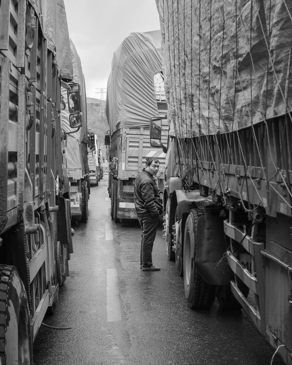 Man standing between trucks Northern China wall art