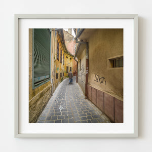 Man walking cobblestone street