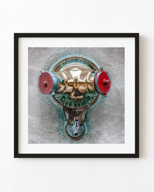Brass standpipe connection with two red caps on a textured Manhattan wall