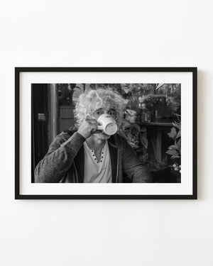 Black and white Manhattan café portrait of a person raising a coffee mug
