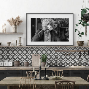 White coffee mug partly covers the face in a monochrome café portrait