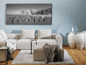 Monochrome New York skyline with calm water and trees along the right shoreline
