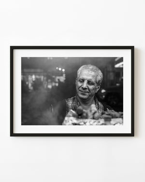 Black and white portrait of Manhattan street food vendor at grill
