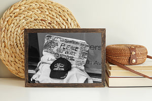 detailed cardboard sign with text and veteran hat foreground