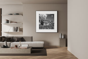 Abandoned prairie farm building with collapsed roof in black and white
