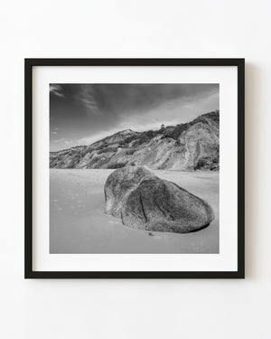 Black and white Martha’s Vineyard beach with a large boulder and Gay Head Lighthouse