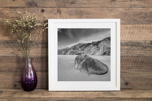 Beach boulder and distant lighthouse form a black and white Martha’s Vineyard landscape