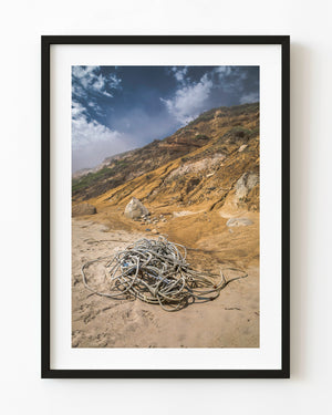 Coiled rope on a Martha’s Vineyard beach below golden coastal cliffs