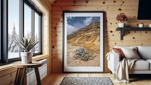 Weathered rope coils across a sandy beach beneath layered coastal bluffs