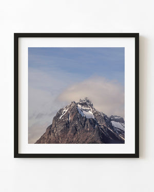 Rocky Martial Mountains summit with patches of snow beneath low cloud
