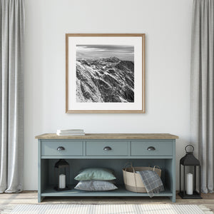 Black and white mountain photograph with diagonal snow lines and layered summits