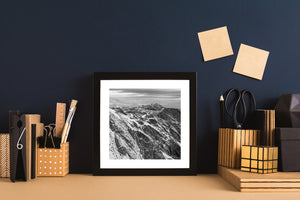 Snow-streaked Martial Mountains ridges extend beneath an overcast sky