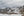Snowy Martial Mountains and a distant helicopter beneath an overcast sky