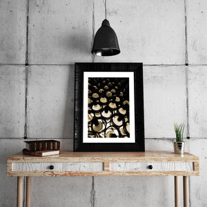 Wine bottles recede into shadow in a warm still-life photograph