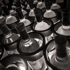 Monochrome pattern of wine bottle necks in cellar rack