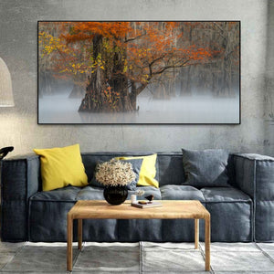 Living room with a large wall art of a tree with autumn leaves, gray sofa with yellow and gray pillows, and wooden coffee table.