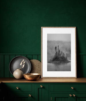Dark island trees contrast with a forest hillside fading into Newfoundland fog