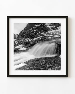 Black and white Molneva waterfall beneath a snow-streaked mountain in Lofoten