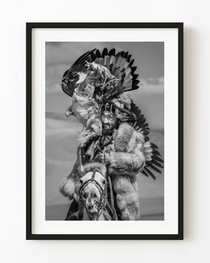 Black and white Mongolian eagle hunter riding a horse