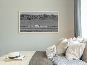 Panoramic Mongolian landscape with layered mountains and a distant camp