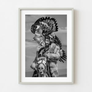 Black and white Mongolian eagle hunter riding a horse
