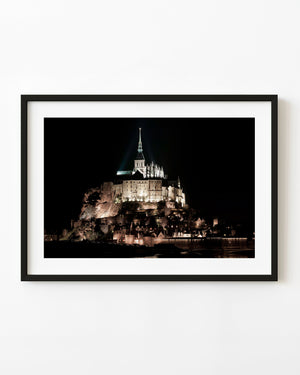 Mont Saint-Michel abbey illuminated against a dark night sky