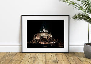 Colour night photograph of Mont Saint-Michel rising above its village