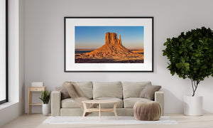 Panoramic desert photograph of a towering butte and distant mesas